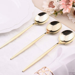 Set of three elegant gold spoons on a table setting.