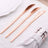 Set of three elegant rose gold butter knives on a soft white tablecloth.