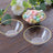 Clear plastic bowls with gold trim and pastel candy on a wooden surface.
