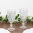 Elegant glass goblets with intricate designs on a wooden table.
