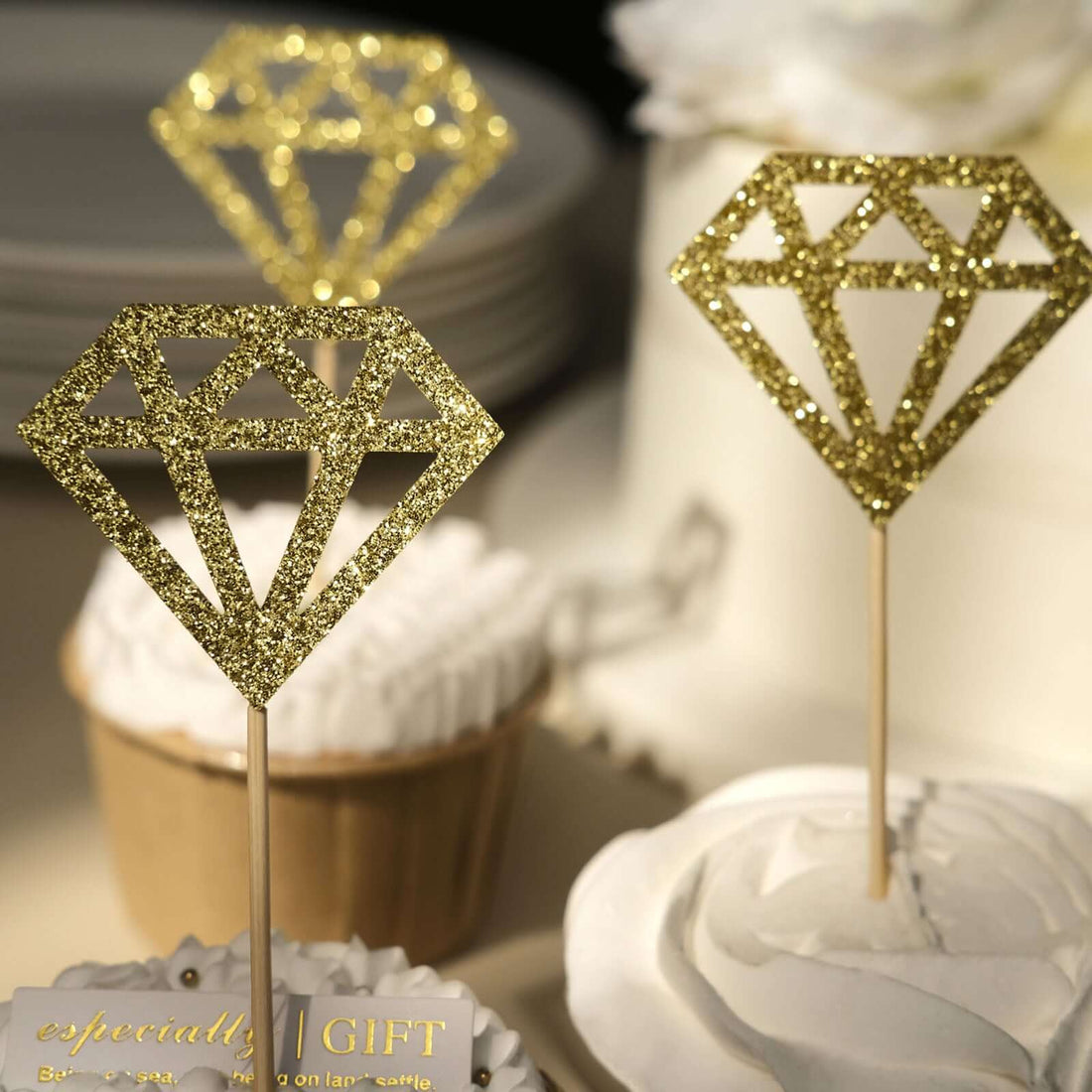 Gold glitter diamond cake toppers on cupcakes.