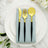 Elegant gold cutlery set on a light blue napkin atop a white plate.