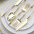 Elegant gold cutlery set on a white plate with gold rim.