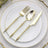 Elegant gold cutlery set on a white plate with a decorative rim.
