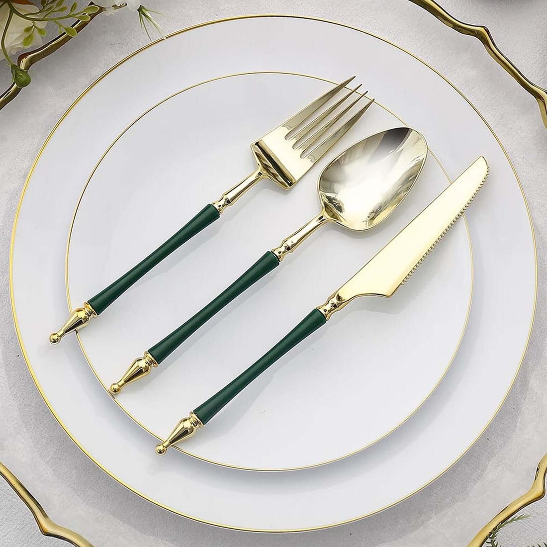 Gold-accented cutlery set with green handles on a white plate