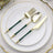 Gold-accented cutlery set with green handles on a white plate