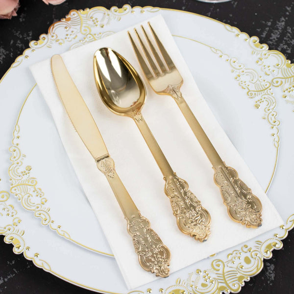 Elegant gold cutlery set on a decorative plate with a napkin.