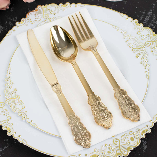 Elegant gold cutlery set on a decorative plate with a napkin.