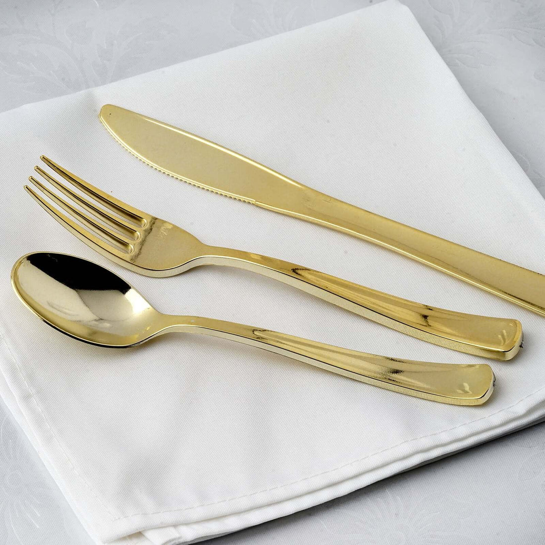 Gold cutlery set on a white napkin.