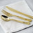 Gold cutlery set on a white napkin.