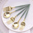 Gold and green cutlery set on a white plate