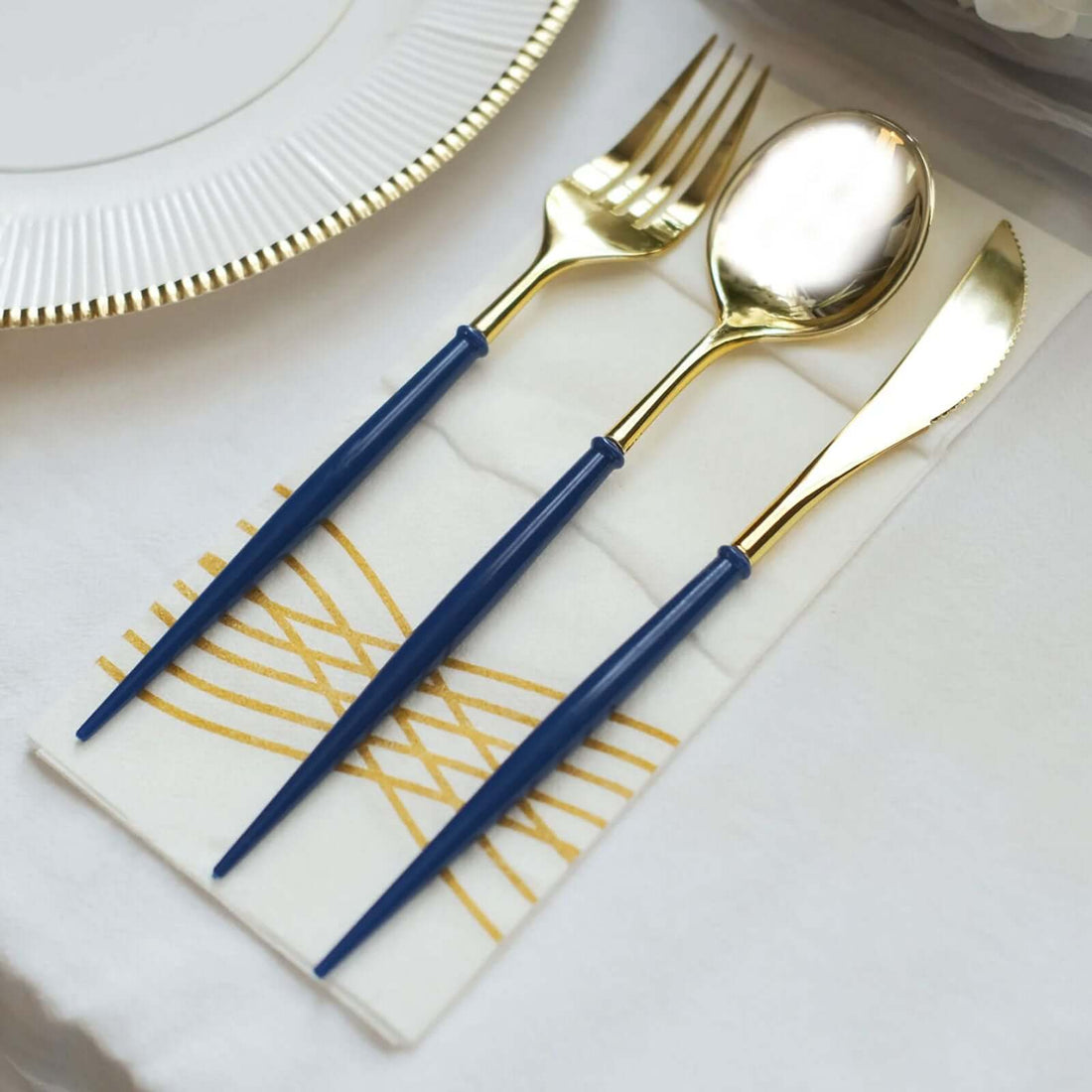 Elegant gold and navy cutlery set on a stylish napkin.