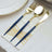 Elegant gold and navy cutlery set on a stylish napkin.