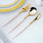 Elegant gold and pink cutlery set on a textured tablecloth.