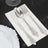 Elegant silver cutlery set on a white napkin with decorative plate