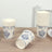 Floral design disposable cups stacked and one tipped over on a wooden table.
