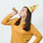 Woman in a party hat blowing a noisemaker, celebrating joyfully.