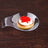 Stylish glass dish with a canapé topped with cream and red caviar.