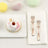 Decorative donut on a plate with forks and pastel treats