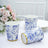Floral patterned disposable cups with gold trim on a table setting.