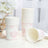 Pink floral paper cups stacked next to a vase with flowers.