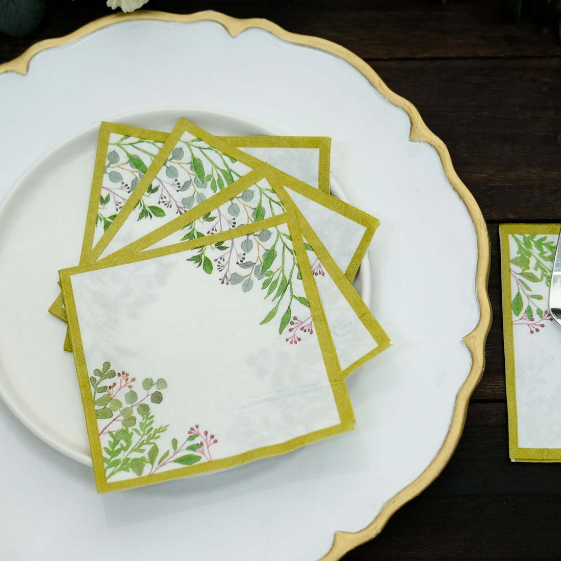 Decorative paper napkins with botanical design on a white plate.