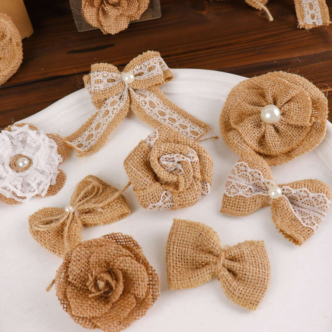 Assorted burlap flowers and bows on a white plate.