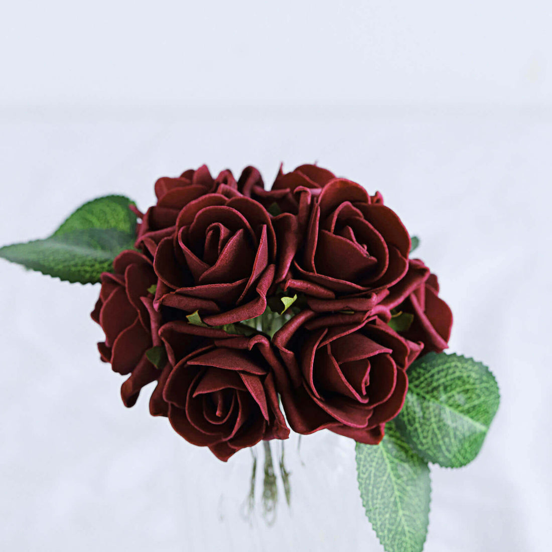 Burgundy artificial rose bouquet with green leaves