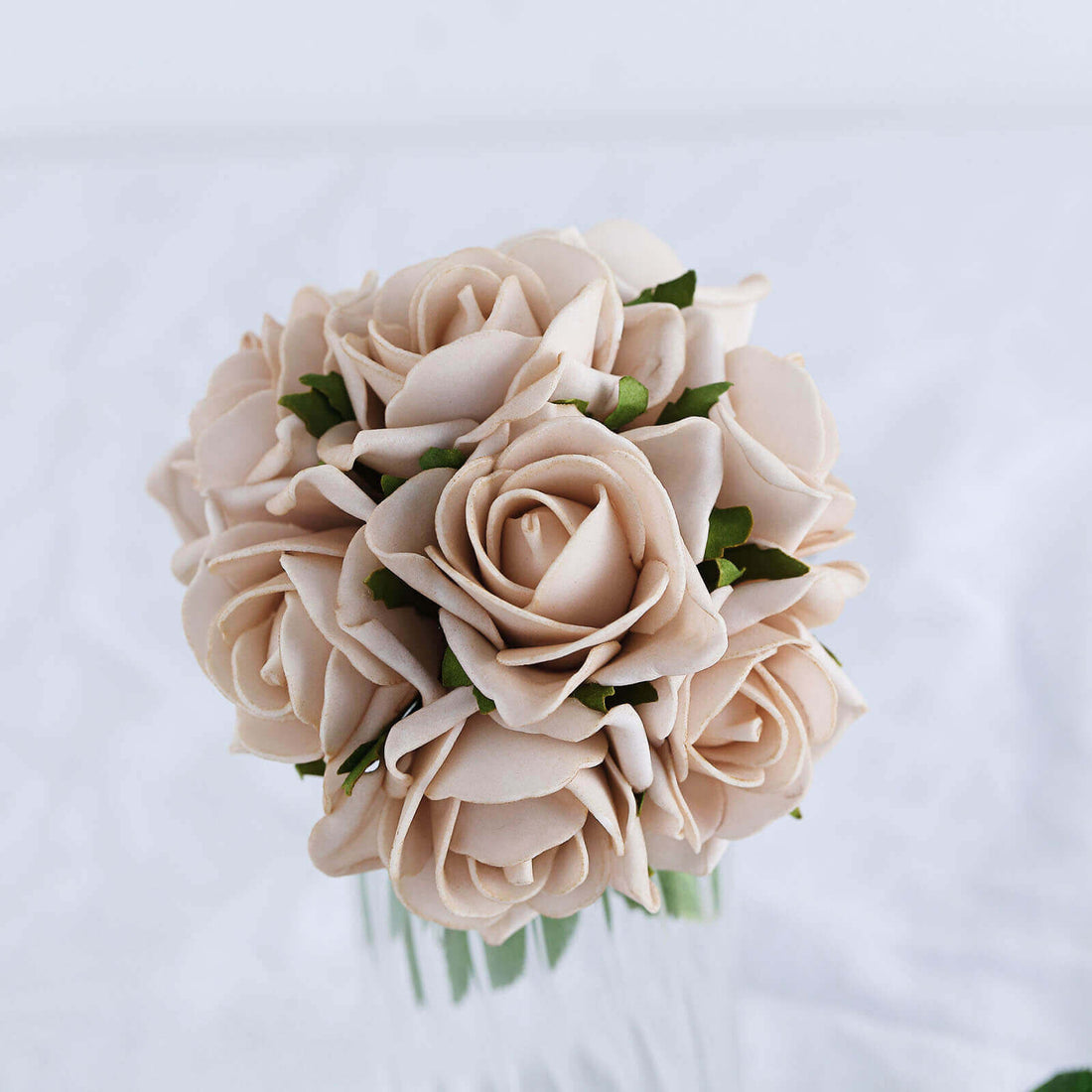 Beige rose bouquet in a clear vase on a white background