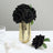Black fabric roses in a gold vase with a decorative accent