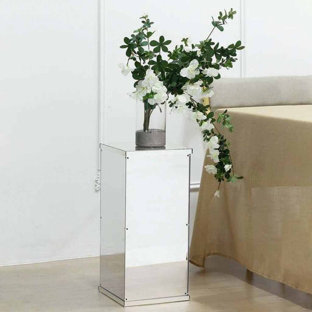 Mirrored side table with flowers and vase, modern decor piece.