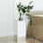 Mirrored side table with flowers and vase, modern decor piece.