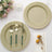 Elegant green and gold table setting with decorative plates and cutlery.