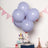 Purple balloons tied to a gift box with a bow.
