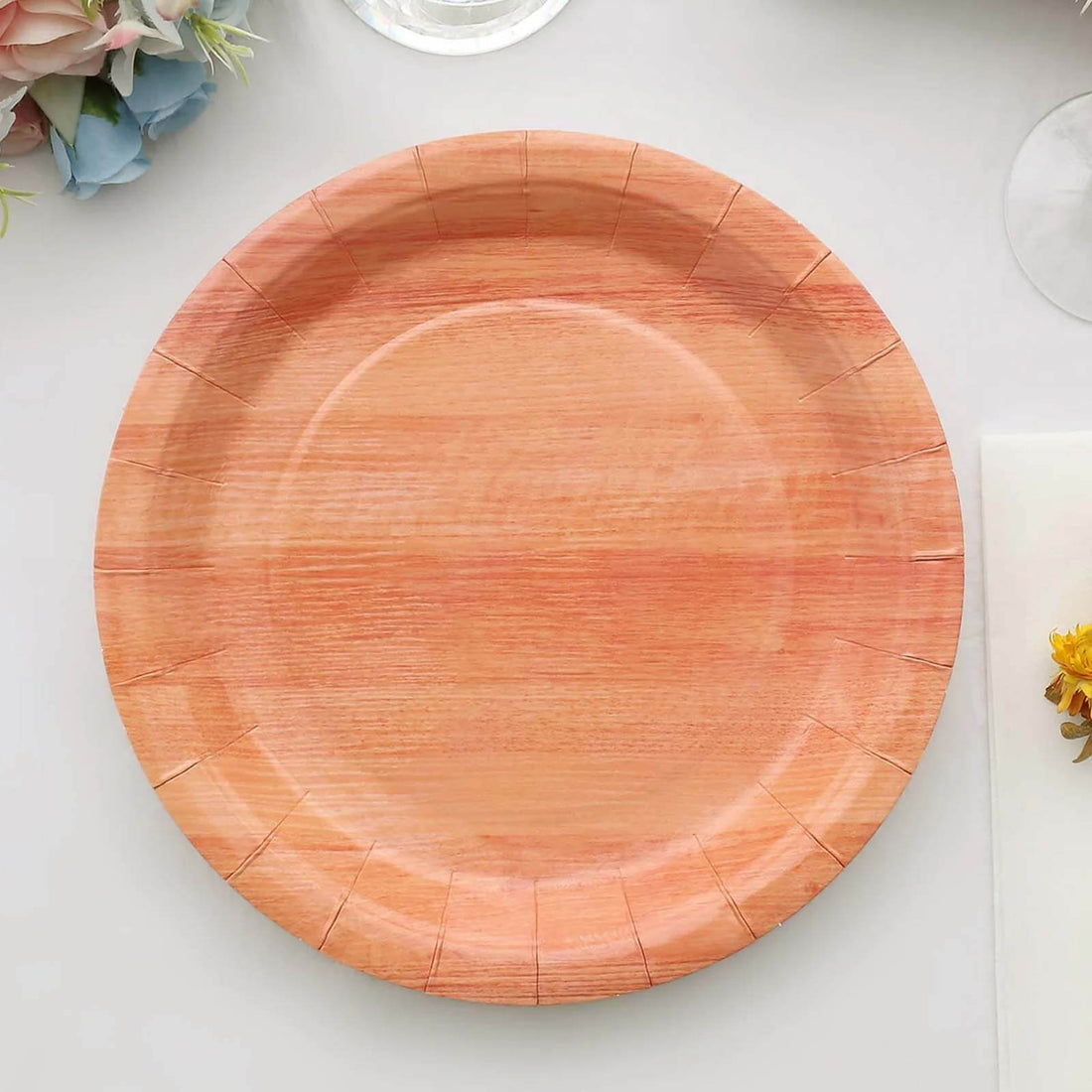 Pink wooden plate with decorative edge on a plain background.