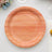Pink wooden plate with decorative edge on a plain background.