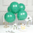 Green balloons arranged with a cake and flowers on a table.