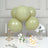 Green balloons arrangement with dessert and floral accents in a stylish setting.