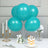 Teal balloons grouped with flowers and dessert on a table setting.