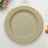 Green decorative plate with gold rim on a white background.