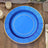 Blue decorative plate with gold trim on a wooden surface.