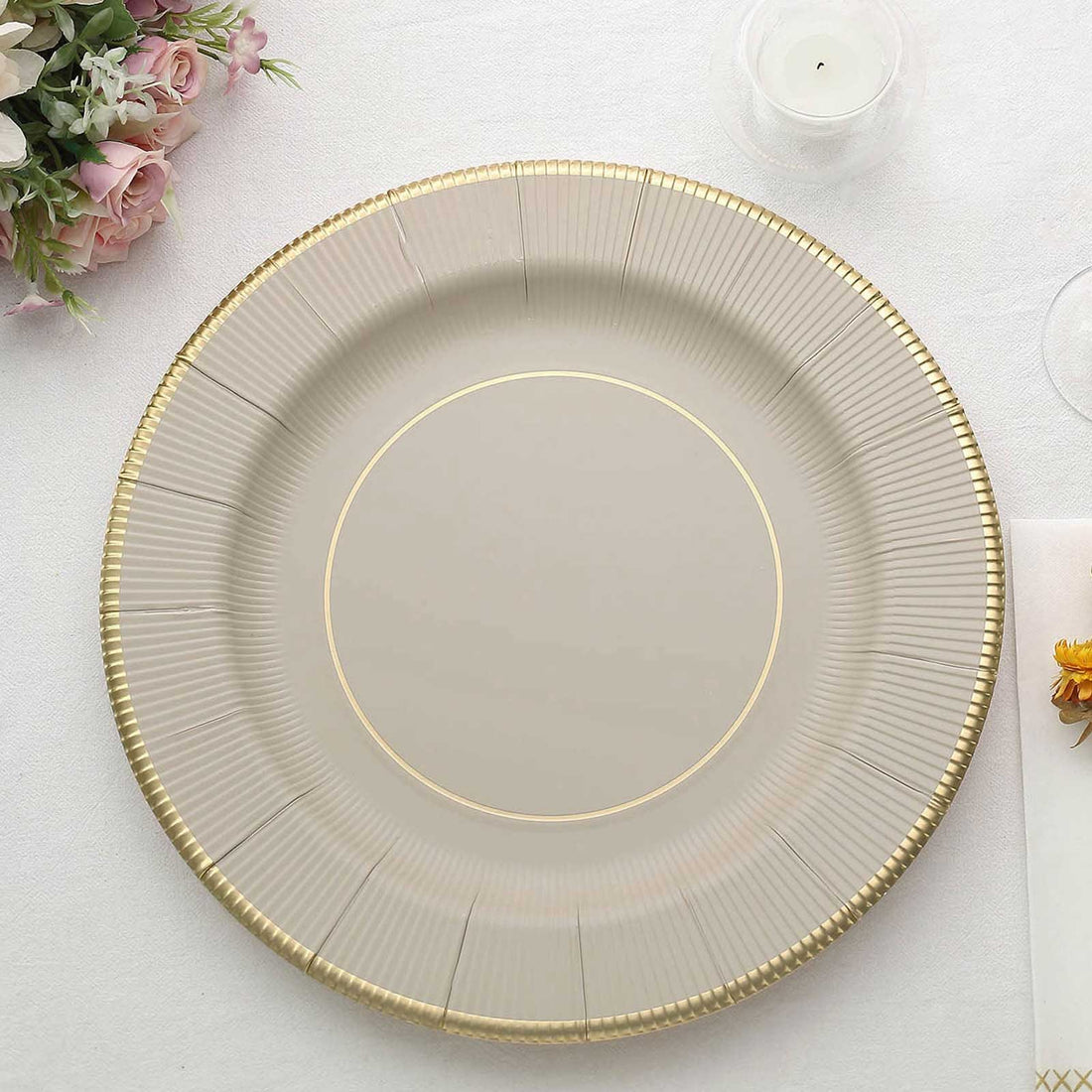 Elegant round charger plate with a gold rim and textured design.