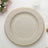 Elegant round charger plate with a gold rim and textured design.
