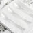 Clear plastic spoons with sparkles on a white tablecloth
