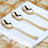 Three elegant gold spoons arranged on a white napkin.