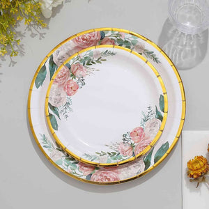 Floral design plates with gold trim, stacked on a grey surface.