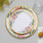 Floral design plates with gold trim, stacked on a grey surface.