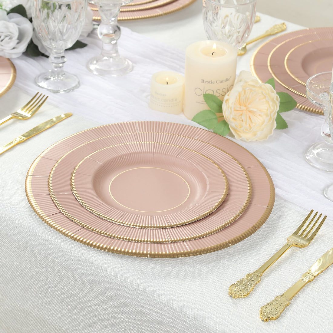 Elegant pink and gold dinnerware set on a beautifully arranged dining table.