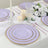 Lavender disposable plates with gold rims on an elegantly set table.