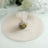 Colorful candy in a tulle bag on a soft, round fabric backdrop.